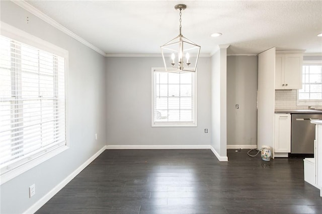 unfurnished dining area with dark wood-style flooring, baseboards, an inviting chandelier, and crown molding