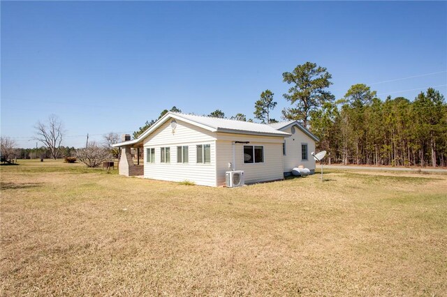 view of property exterior featuring a lawn and ac unit