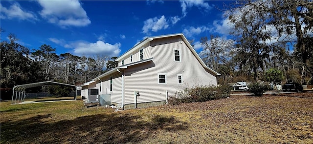 view of property exterior with a carport, central air condition unit, and a lawn