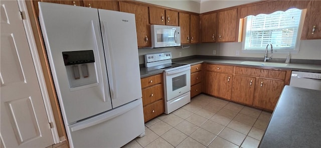 kitchen with sink, light tile patterned floors, and white appliances