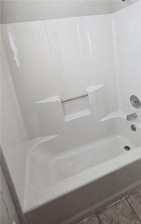 bathroom featuring tile patterned flooring and  shower combination