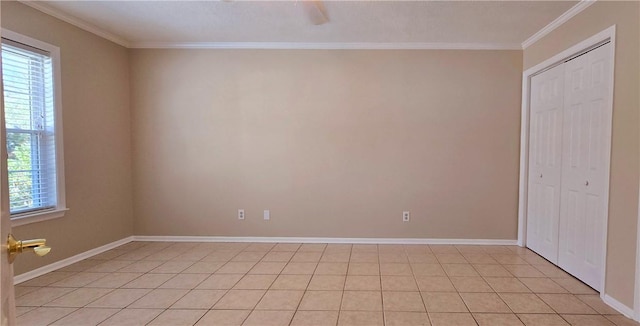 empty room featuring crown molding and light tile patterned flooring