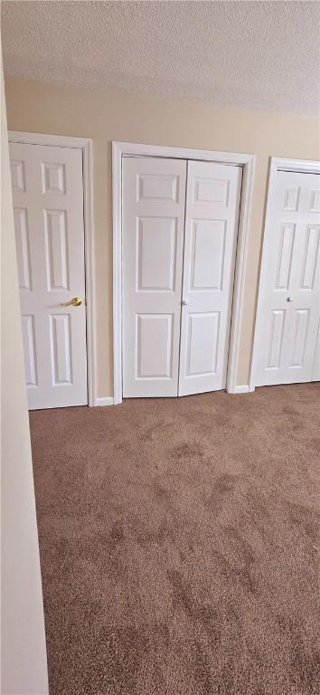 unfurnished bedroom featuring a closet, carpet, and a textured ceiling