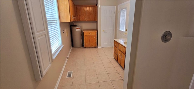 kitchen with plenty of natural light, water heater, and light tile patterned floors