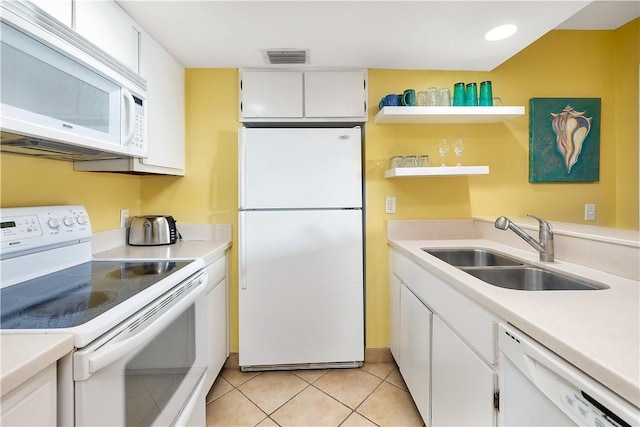 kitchen featuring white cabinets, light tile patterned flooring, white appliances, and sink