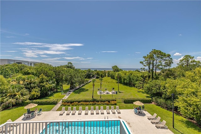 view of swimming pool featuring a patio area and a yard