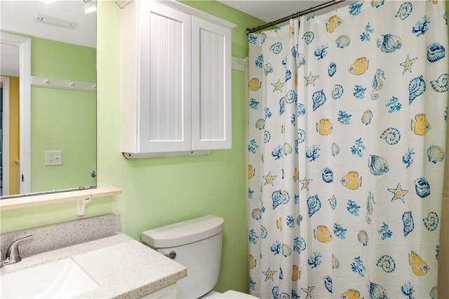 bathroom with vanity, curtained shower, and toilet