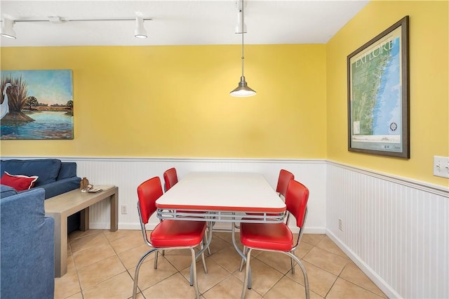 dining area with light tile patterned floors and rail lighting