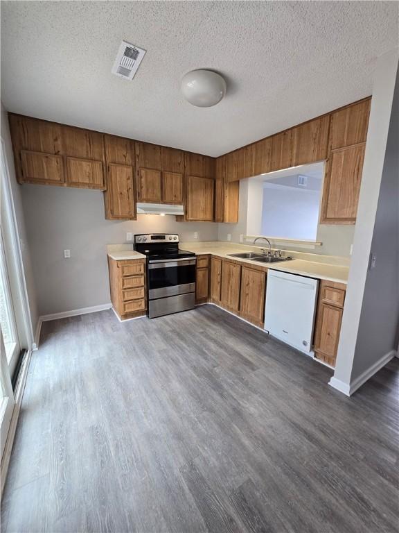 900 Lanier Blvd Unit 6, Brunswick, GA 31520 - kitchen with electric stove, dishwasher, under cabinet range hood, brown cabinets, and light countertops