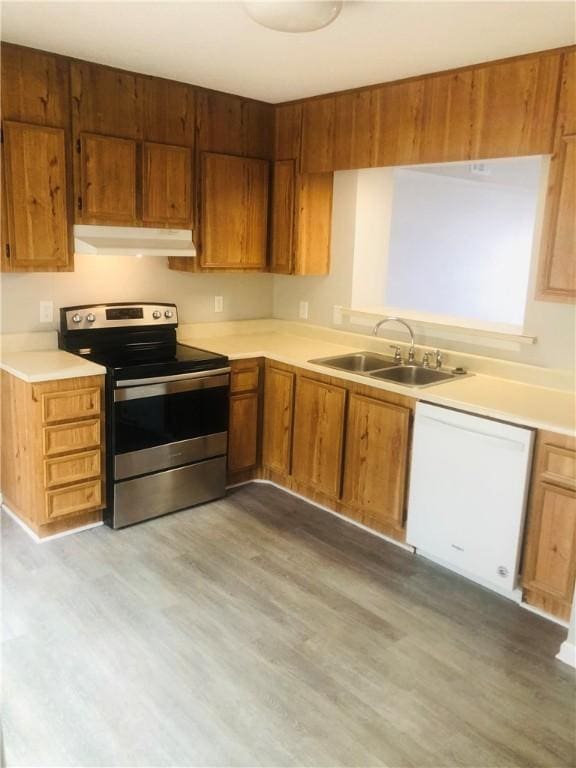 900 Lanier Blvd Unit 6, Brunswick, GA 31520 - kitchen with stainless steel electric range oven, dishwasher, under cabinet range hood, light countertops, and wood finished floors