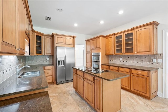 340 Oak Grove Island Dr, Brunswick, GA 31523 - kitchen with appliances with stainless steel finishes, decorative backsplash, dark stone countertops, a kitchen island, and glass insert cabinets