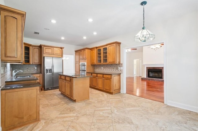 340 Oak Grove Island Dr, Brunswick, GA 31523 - kitchen with appliances with stainless steel finishes, dark countertops, a center island, tasteful backsplash, and glass insert cabinets