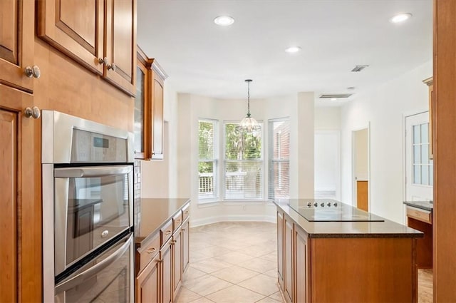 340 Oak Grove Island Dr, Brunswick, GA 31523 - kitchen with black electric stovetop, light tile patterned floors, a kitchen island, pendant lighting, and brown cabinets
