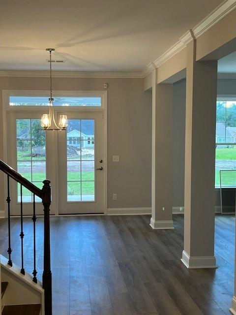 doorway to outside with crown molding, dark hardwood / wood-style flooring, and a notable chandelier