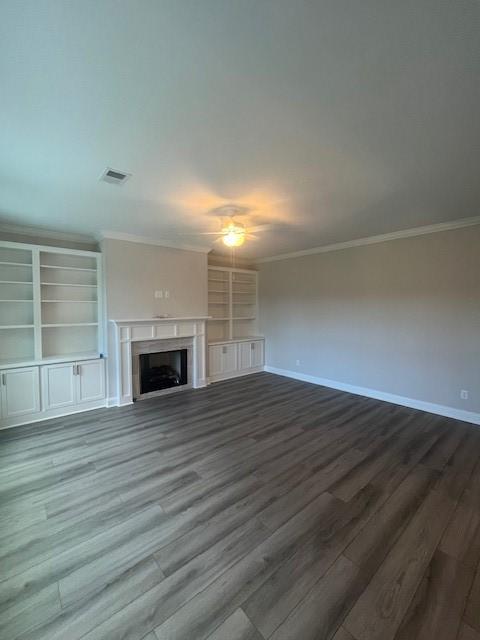 unfurnished living room with ornamental molding and hardwood / wood-style flooring