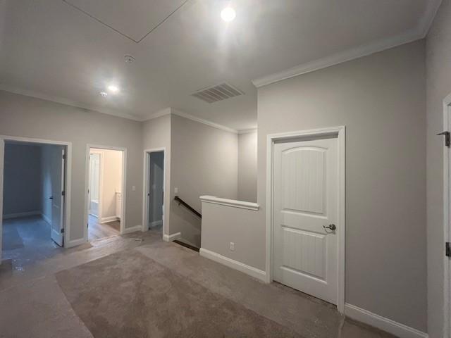 carpeted spare room featuring crown molding