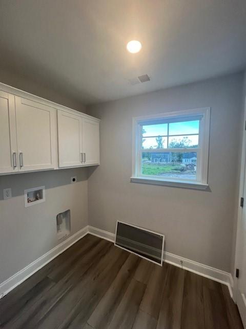 clothes washing area featuring electric dryer hookup, cabinets, dark wood-type flooring, and hookup for a washing machine