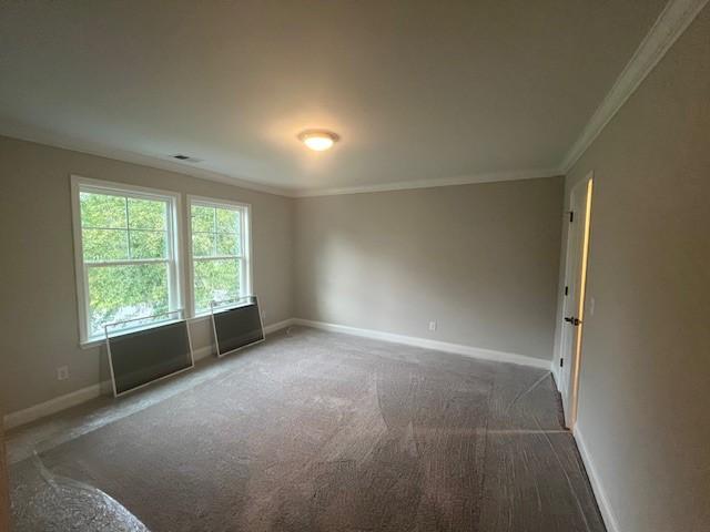 carpeted empty room featuring crown molding