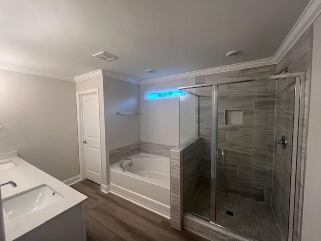 bathroom featuring hardwood / wood-style floors, vanity, crown molding, and independent shower and bath