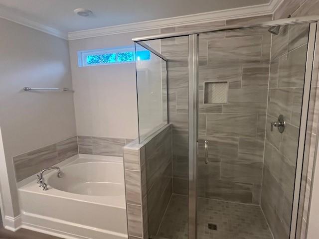 bathroom featuring plus walk in shower and ornamental molding