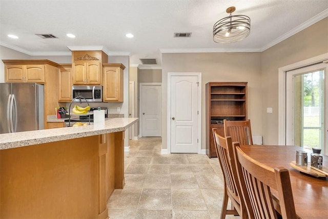 kitchen featuring appliances with stainless steel finishes, light brown cabinets, light stone counters, and visible vents