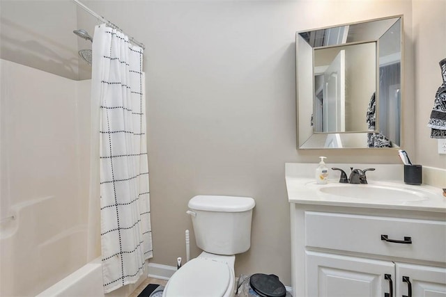 bathroom with shower / bath combo, toilet, vanity, and baseboards