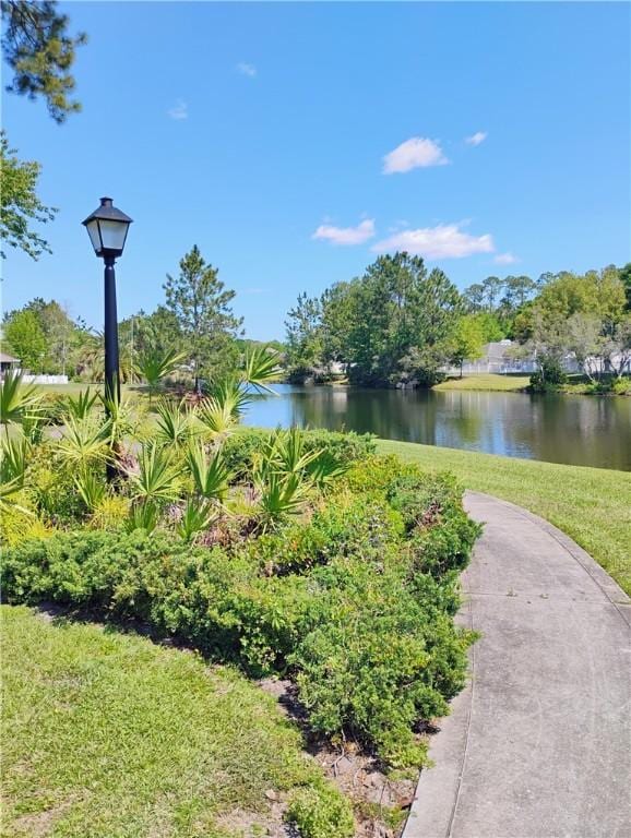 view of community featuring a yard and a water view