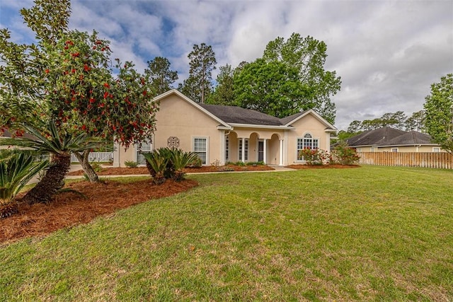 view of front facade featuring stucco siding, fence, and a front lawn