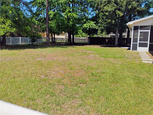 view of yard with a fenced backyard and a sunroom