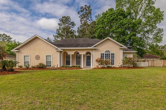 ranch-style house with a front yard, fence, and stucco siding