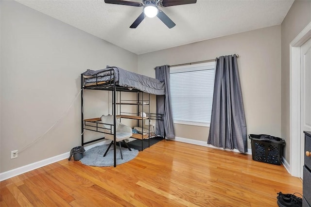 bedroom featuring wood finished floors, ceiling fan, and baseboards