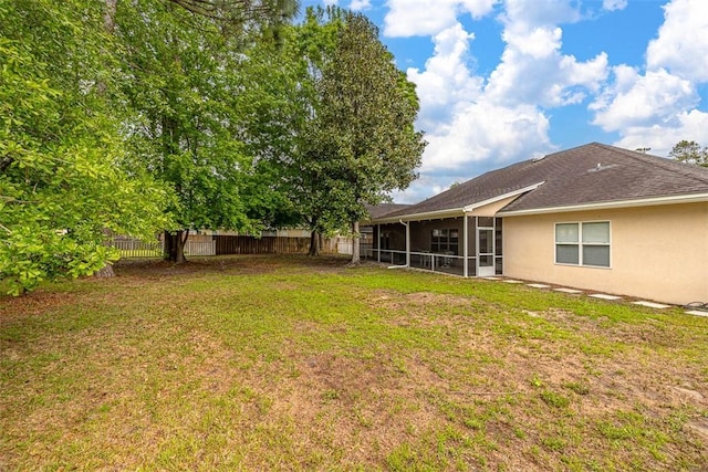 view of yard with a sunroom and fence