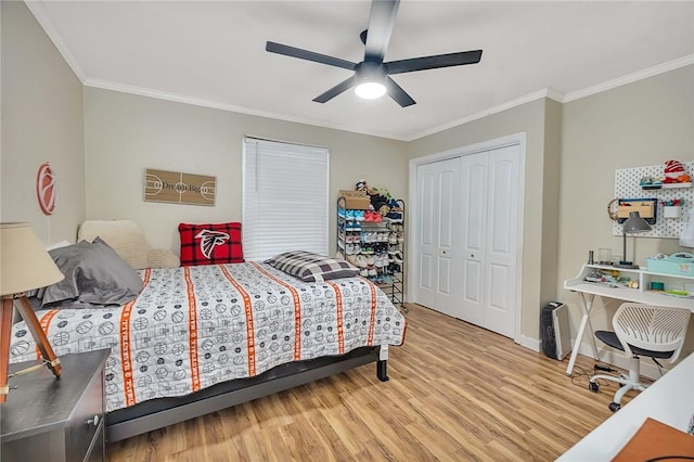 bedroom with ceiling fan, light hardwood / wood-style floors, ornamental molding, and a closet