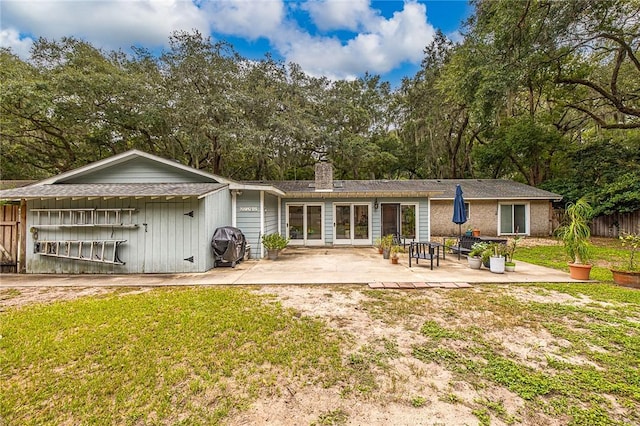 rear view of property featuring a yard and a patio area