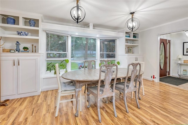 dining space featuring crown molding, light hardwood / wood-style floors, and an inviting chandelier