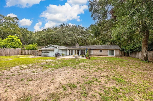 rear view of property featuring a yard and a patio area