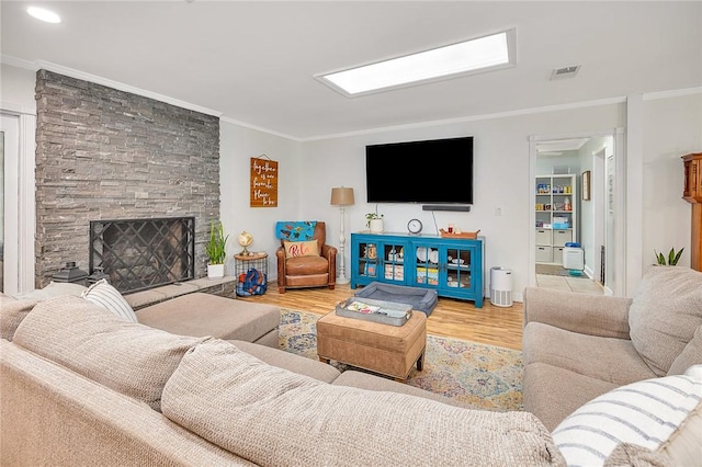 living room featuring a fireplace, light wood-type flooring, and ornamental molding