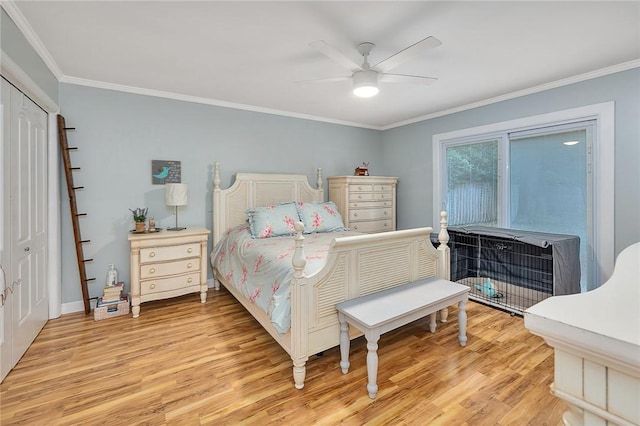 bedroom featuring ceiling fan, light wood-type flooring, crown molding, and a closet