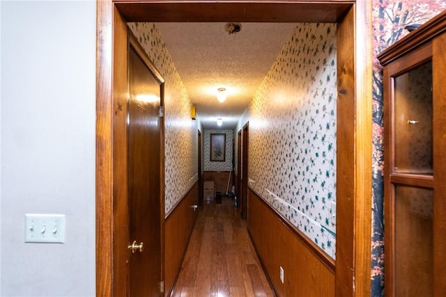 corridor featuring hardwood / wood-style floors and a textured ceiling