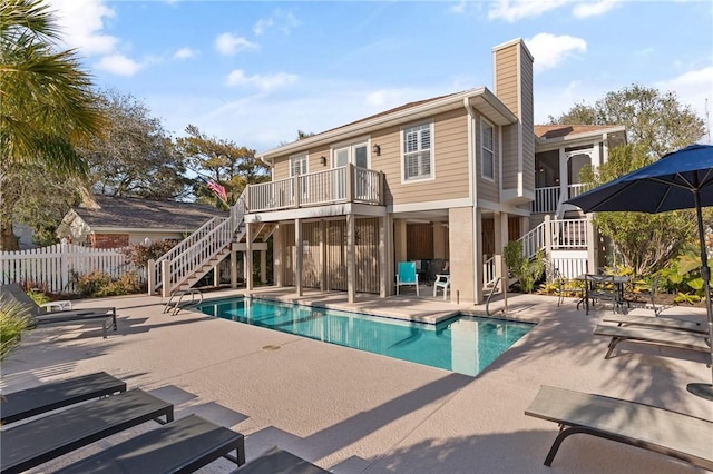 view of swimming pool featuring a sunroom and a patio area