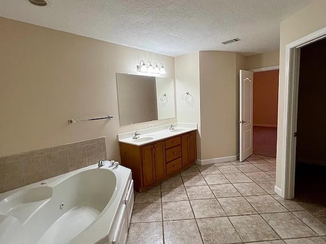 bathroom with vanity, a textured ceiling, tile patterned floors, and a tub