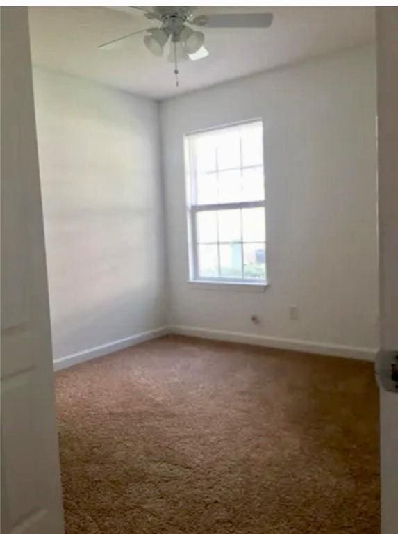 carpeted empty room featuring ceiling fan