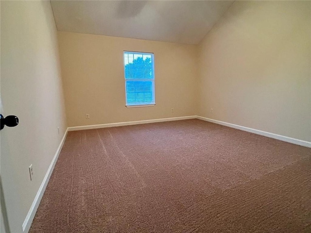 empty room featuring carpet flooring and lofted ceiling