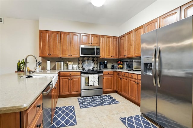 760 Ocean Blvd Unit 201, Saint Simons Island, GA 31522 - kitchen featuring stainless steel appliances, a peninsula, brown cabinets, and light tile patterned floors