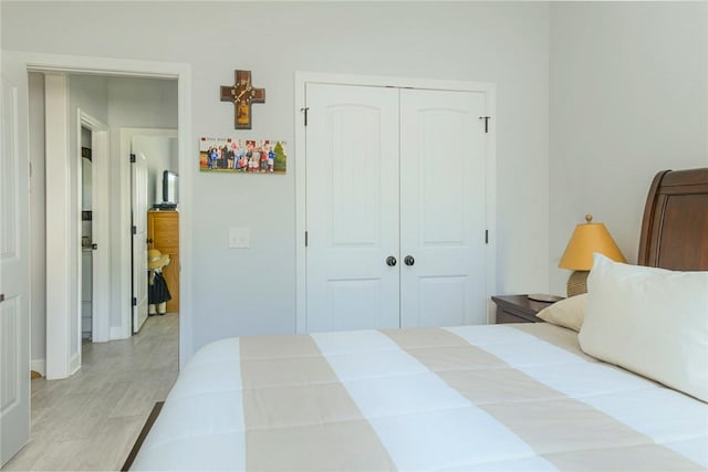 bedroom with light wood finished floors and a closet