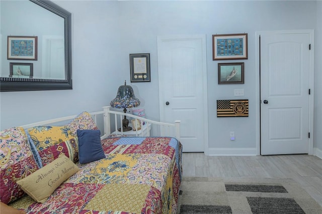 bedroom with baseboards and wood finished floors