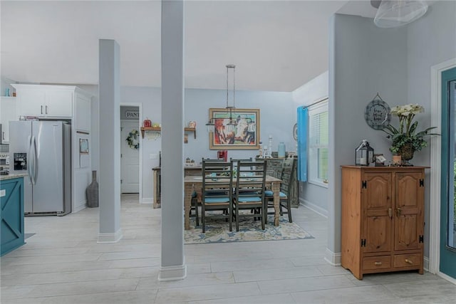 dining space featuring baseboards and light wood finished floors