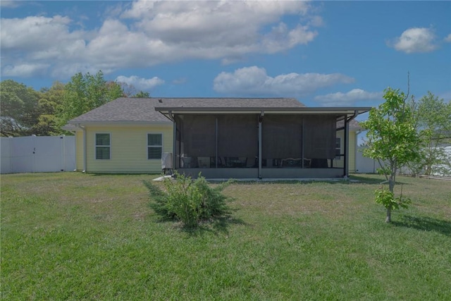 back of property featuring a sunroom, a lawn, and fence