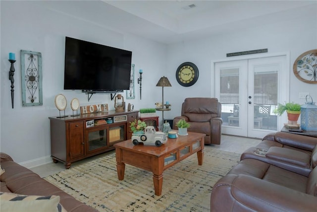 living area featuring french doors, visible vents, and baseboards