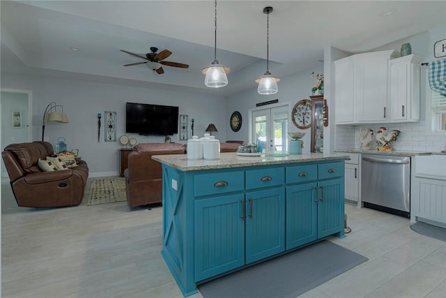 kitchen with blue cabinets, a tray ceiling, white cabinets, and dishwasher